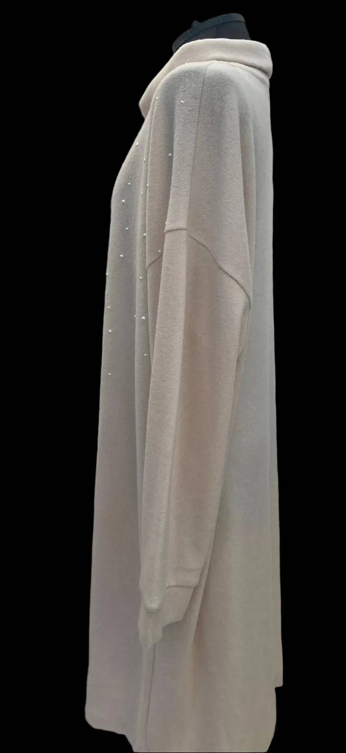 Close-up of pearl embellishments on cream jumper dress fabric