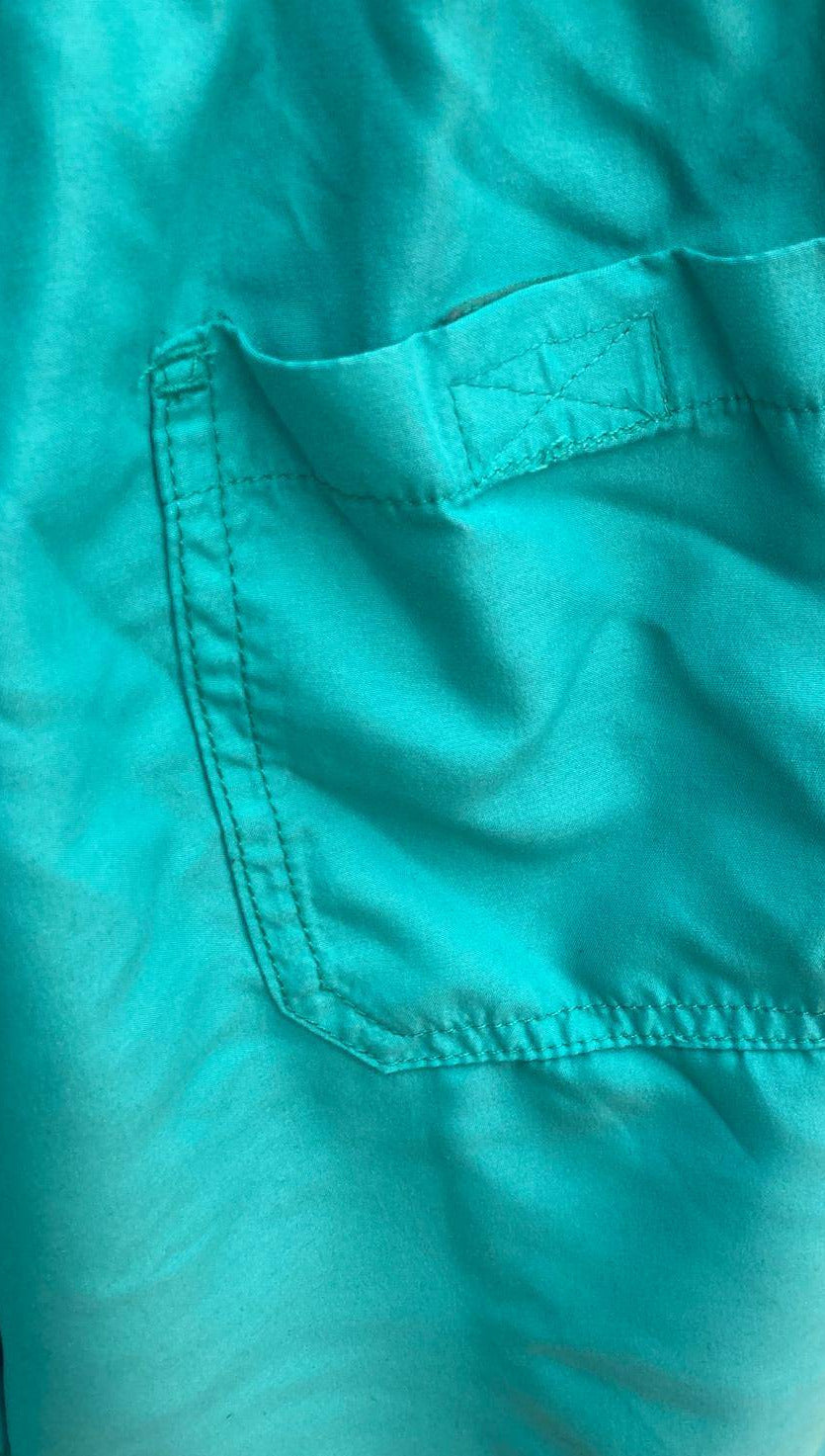 Back pocket detail of turquoise swim shorts