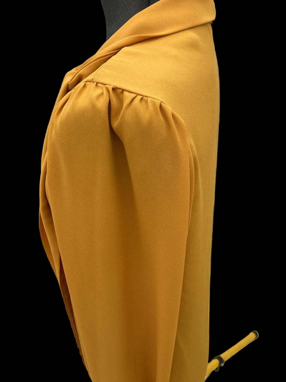 Side view of mustard yellow blouse with puffed sleeve design