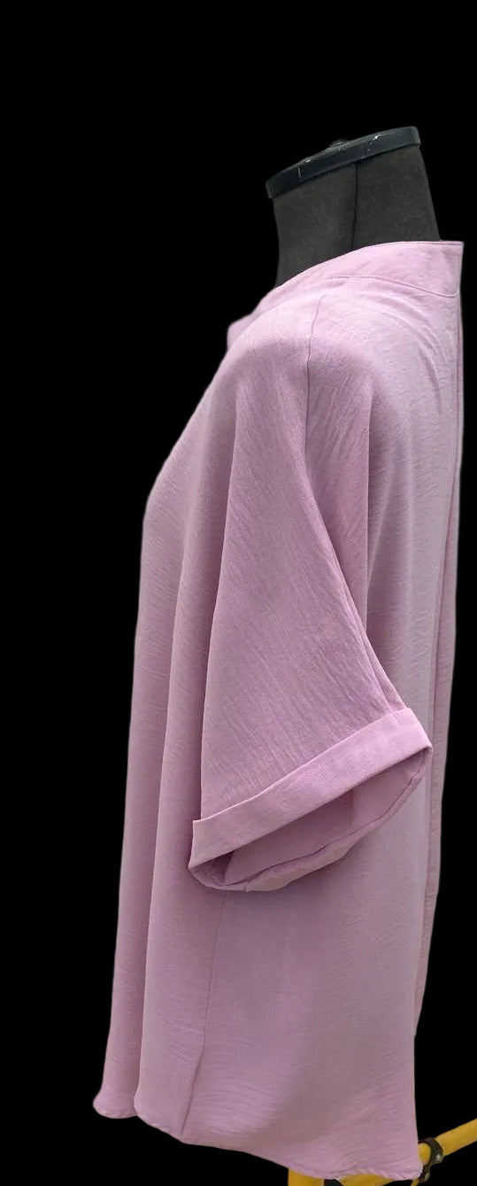 Side view of pink tunic blouse with rolled sleeves