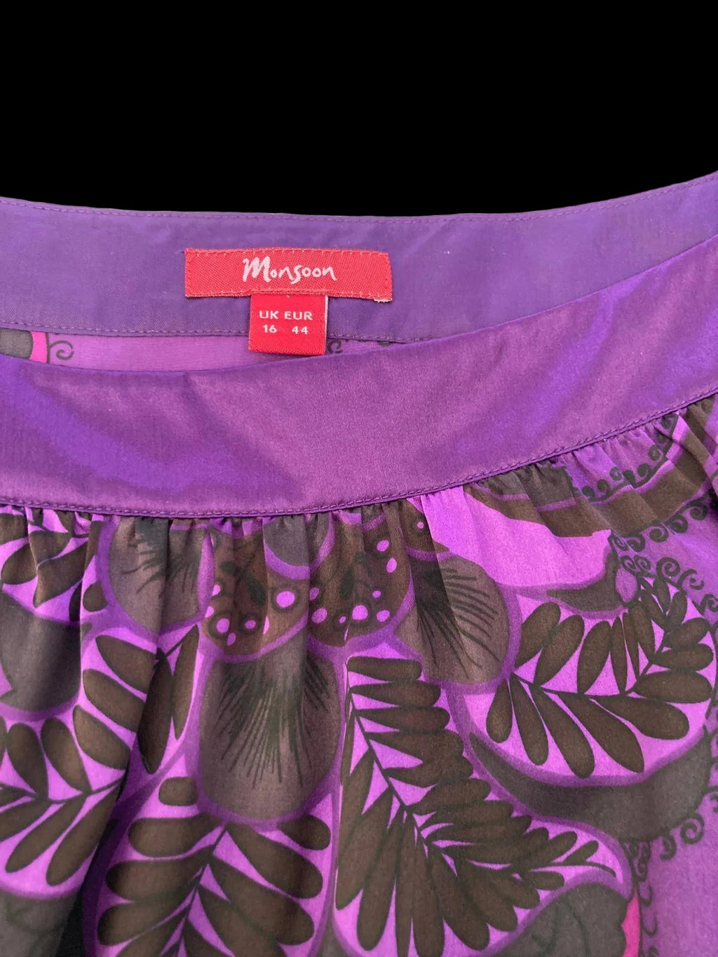 Close-up of purple silk dress fabric and embroidery