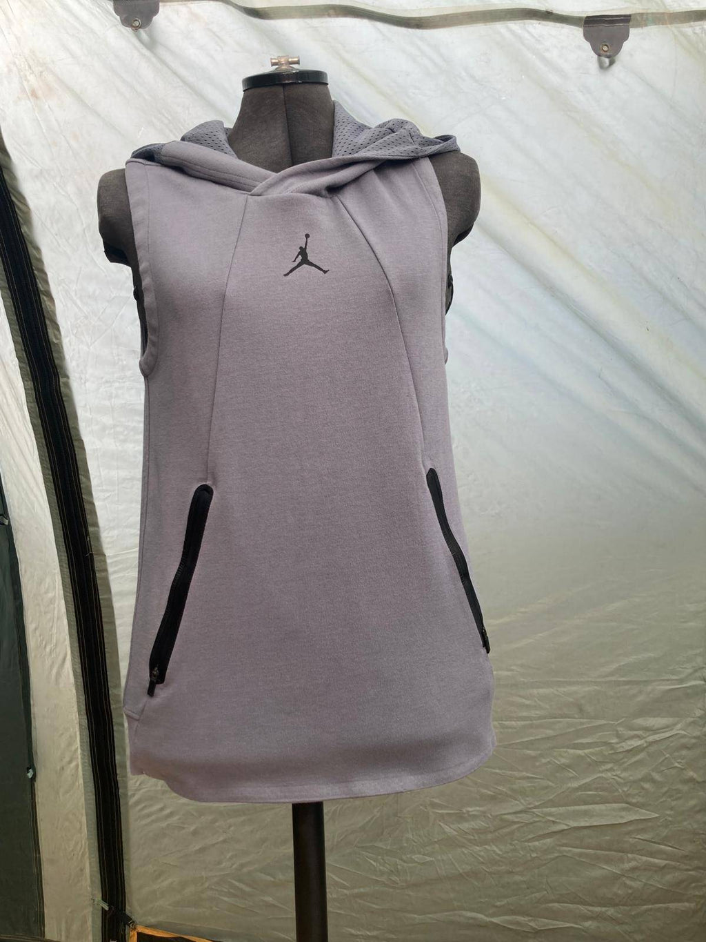 Gray sleeveless hoodie with side pockets on mannequin for casual activewear